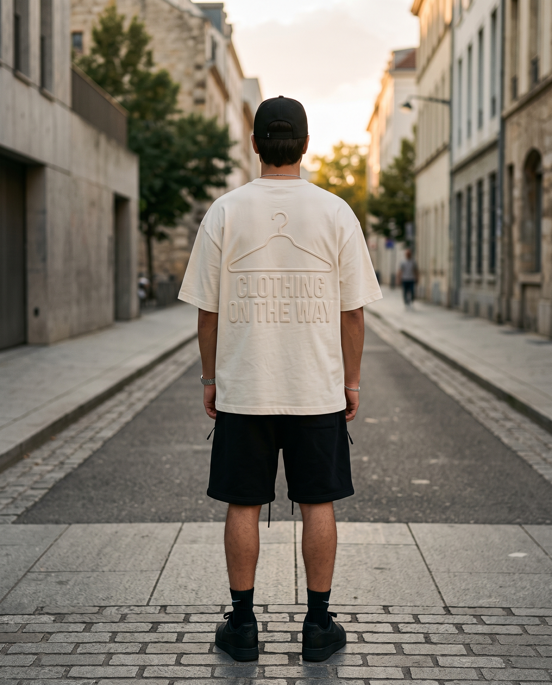 Model in the charcoal embossed tee and khaki chino shorts against a concrete wall